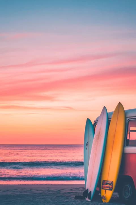 Surfeur au bord de la plage au coucher du soleil